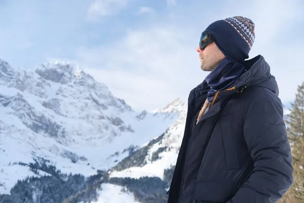 young man wearing sunglasses, mountain hiker admiring mountain winter landscape, Sports Concept, Healthy Lifestyle, Winter Activity, beautiful winter natural landscape, walks in winter white forest