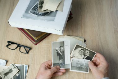 Yaşlı bir adam 1950-1955 yılları arasındaki eski fotoğraflarına, nostalji konseptine, gençlik anılarına, çocukluk anılarına, hayatını, akrabalarını, nesillerin aile bağlarını hatırlar.