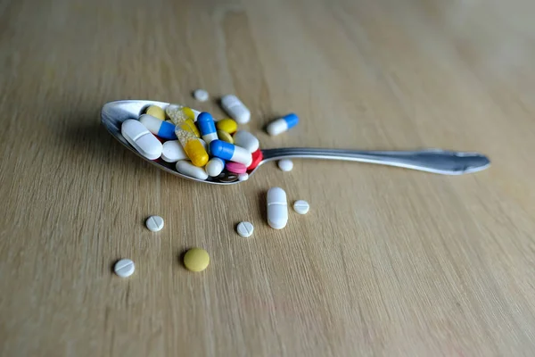 多くの色の錠剤 粉末をスプーンで軽く背景にしたカプセル 薬物治療 ビタミン 栄養補助食品 薬物中毒を維持するという概念 — ストック写真
