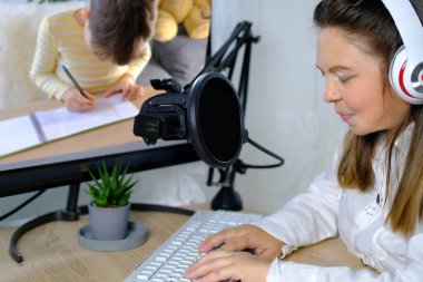 40-45 yaşlarındaki kadın, yabancı dil öğretmeni internetten bir ders veriyor, 8-10 yaşındaki çocuk kelimeleri yazıyor, uzaktan öğrenme kavramı, kilit altına alınan covid-19