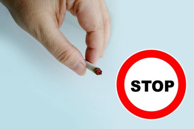 cigarette butt in female hand, concept of nicotine poisoning, addiction treatment, quit smoking, harm of smoking to health, environmental pollution