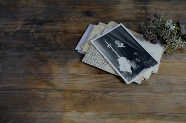 Doğal ahşap masa üzerinde 50-60 'lı yılların eski monokrom fotoğrafları, çocuğun fotoğrafı, kurumuş çiçekler, aile ağacı konsepti, soy ağacı, atalarla bağlantı, gençlik anıları, çocukluk anıları.