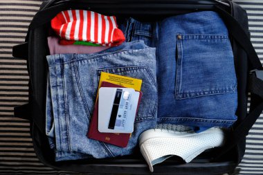 Yakın plan çekimler, belgeler kanepenin üzerinde siyah açık bir bavula konsept yaz tatili, iş seyahati, uzun zamandır beklenen bir yolculuğa çıkmak.