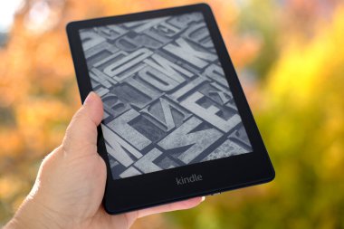 Kadınlar ellerinde modern siyah e-kitap okuyucu, dijital kitap Kindle, elektronik metin gösterimi için tablet bilgisayar aygıtı, elektronik kağıt teknolojisi, kurgu okuma kavramı, metin düzenleme