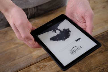 Erkek elleri modern siyah e-kitap okuyucusu, dijital kitap Kindle, elektronik metin gösterimi için tablet bilgisayar aygıtı, elektronik kağıt teknolojisi, kurgu okuma kavramı, metin düzenleme