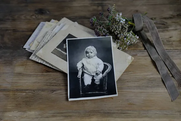 木のテーブルの上の50 60年代のレトロなモノクローム写真のスタック 子供の写真 ドライフラワー 家族の木の概念 祖先との接続 若者の思い出 小児期 — ストック写真