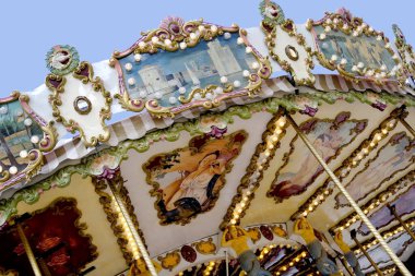 Çocuklar için atlıkarınca, çok renkli ampullerle, dekorasyonlarla süslenmiş, neşeyle dönen, çocuklar için atların olduğu lunapark eğlencesi, tatil konsepti, Noel, aile eğlencesi