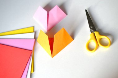 Kağıt, makas, uygulama malzemesi, renkli kağıtlardan origami tekniği, Japon dikiş tekniği, el yapımı ve yaratma konsepti, Sevgililer Günü