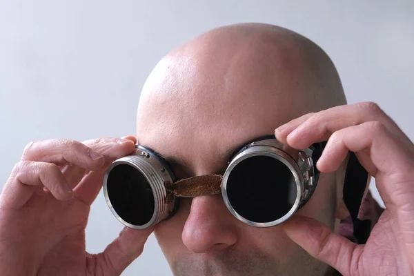 close-up face of a young bald man wearing dark glasses, the concept of watch solar eclipse, bright welding, eye protection at work