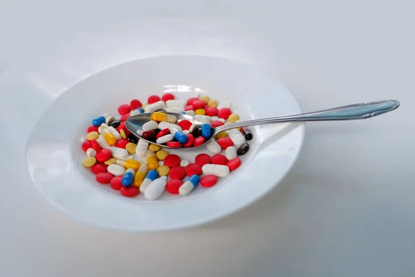 多くの色の錠剤 薄い背景に白いプレートに粉末とカプセル 薬の治療 ビタミン 栄養補助食品 薬物中毒を維持するという概念 — ストック写真