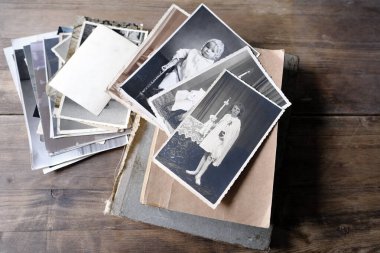 Eski fotoğraf yığınları, 1940-1950 yılları arasında tahta masa, eski kitaplar, soy ağacı konsepti, atalarımızın hafızası, aile ağacı, soy ağacı, çocukluk anıları, aile arşivi.