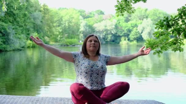 大人の女性45 50歳瞑想の位置に座って薬ヨガAsana水で 禅の概念 バランスKundalini エネルギー毎日ルーチン練習女性の健康のために良いマインドフルネス — ストック動画
