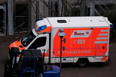 Frankfurt, Almanya - Ocak 2022: Modern Kırmızı sağlık ambulansı acil servis aracı, inşaat alanında sağlık görevlileri yardım sağladı, iş yerinde kaza konsepti, işgücü korumasını ihlal