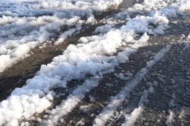 Şehrin bir kısmı, yoğun kar yağışı sonrası kaldırım, ıslak karlar eriyor, su birikintileri, çamur ve çamur yayaların ve araçların hareketini engelliyor, konsept trafik güvenliği, kamu hizmetleri