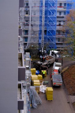 Frankfurt, Almanya - Ocak 2022: Evi tamir eden işçiler, vinçle yalıtım malzemelerini kaldıran işçiler, üretim işi konsepti, konut stoklarının yenilenmesi, özel ekipmanlar