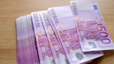Yakın plan kadın eli, Avrupa Birliği 'nin banknotlarını, masadaki dağınık kağıt banknotlar, ödemeler konsepti, tasarruflar, bankacılık, tatil için para biriktirme, para akışı ile karşılaştırıyor