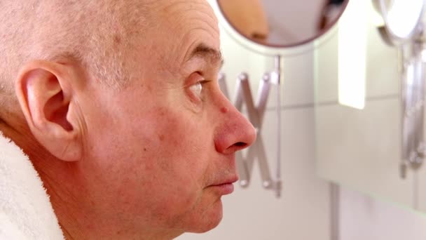 特写有魅力的成熟男人60岁时照镜子 仔细审视自己的脸 因年龄变化而烦恼 中年危机 选择性焦虑症 — 图库视频影像