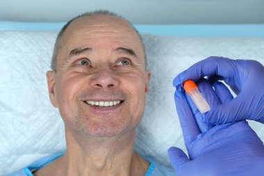 Olgun bir adam, doktorun elleri tükürük örneği, DNA için biyolojik materyal, patoloji, virüsler, ağzından CV19, tıbbi muayene, genetik araştırma, babalık testi...