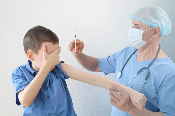 Lekarz Pielęgniarka Niebieskim Mundurze Wykonuje Wstrzyknięcie Strzykawką Chłopca Wieku Lat — Zdjęcie stockowe