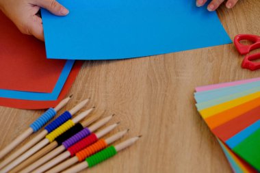 Yakın plan bir kadın elinde mavi renkli bir kağıt tutuyordu. Albüm, origami, kağıt katlama figürleri, iğne işi kavramı, zanaatkarlar el yapımı ve el yapımı.