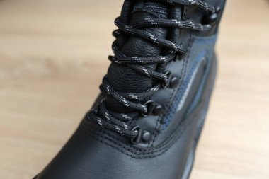 Takviyeli pelerinli deri dantelli yeni bir iş botu ahşap döşeme, özel koruyucu profesyonel ayakkabı konsepti profesyonel iş güvenliği.