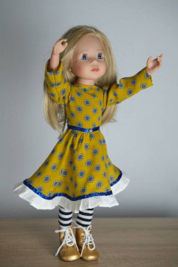 Uzun sarı saçlı, şık elbiseli, ayellow elbiseli, çizmeli oyuncak bebek, oyuncak bebek, hobi, kızlar için mutlu çocukluk.