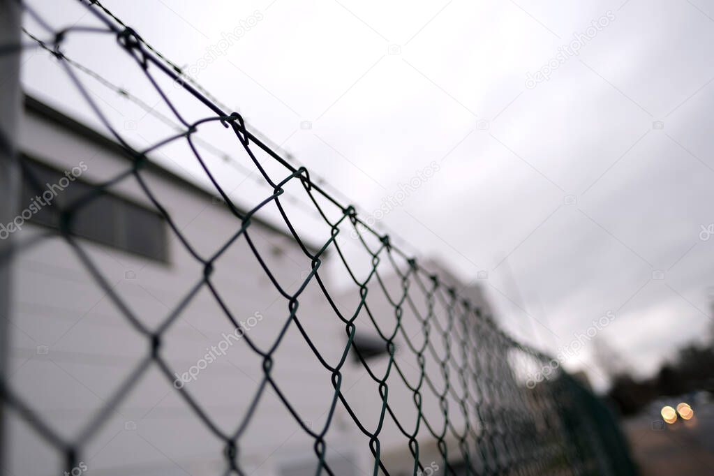 many rows of barbedwire, wire mesh, barbed wire fence on top, building for execution of punishments for criminals, concept prison, security zone, symbol of bondage, hopelessness of captivity