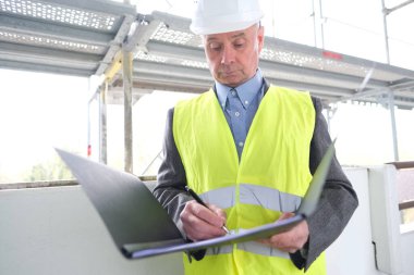 Deneyimli yaşlı inşaatçı, inşaat ekibi lideri, beyaz kask koruma mühendisi inşaat sahasında inşaat yenileme, inşaat mühendisliği konsepti belgeleri imzaladı.