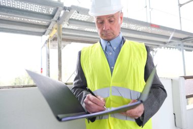 Deneyimli yaşlı inşaatçı, inşaat ekibi lideri, beyaz kask koruma mühendisi inşaat sahasında inşaat yenileme, inşaat mühendisliği konsepti belgeleri imzaladı.