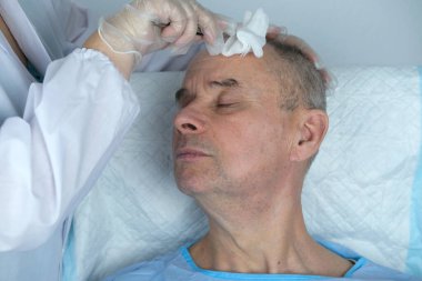 Yakın plan trikoloğu saç büyütme kliniğinde saç dökülmesi olan kel ve olgun bir adamı ve kelleşen erkekler için yaşlanma karşıtı tedavileri tedavi ediyor. Erkekler için saç nakli prosedürleri konsepti, seçici odaklanma