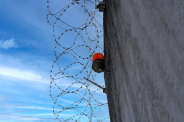 Dikenli teller, yüksek beton çitler, dikenli teller, suçlulara verilen cezaların infazı için bina, konsept hapishane, güvenlik bölgesi, esaretin sembolü, umutsuzluğun esareti.