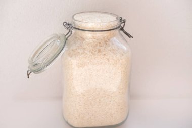 Kapaklı cam kavanozlarda çiğ beyaz pirinç, yağmurlu günler için stratejik gıda stokları, yemek malzemeleri, ekolojik ambalaj, haşere kontrolü.