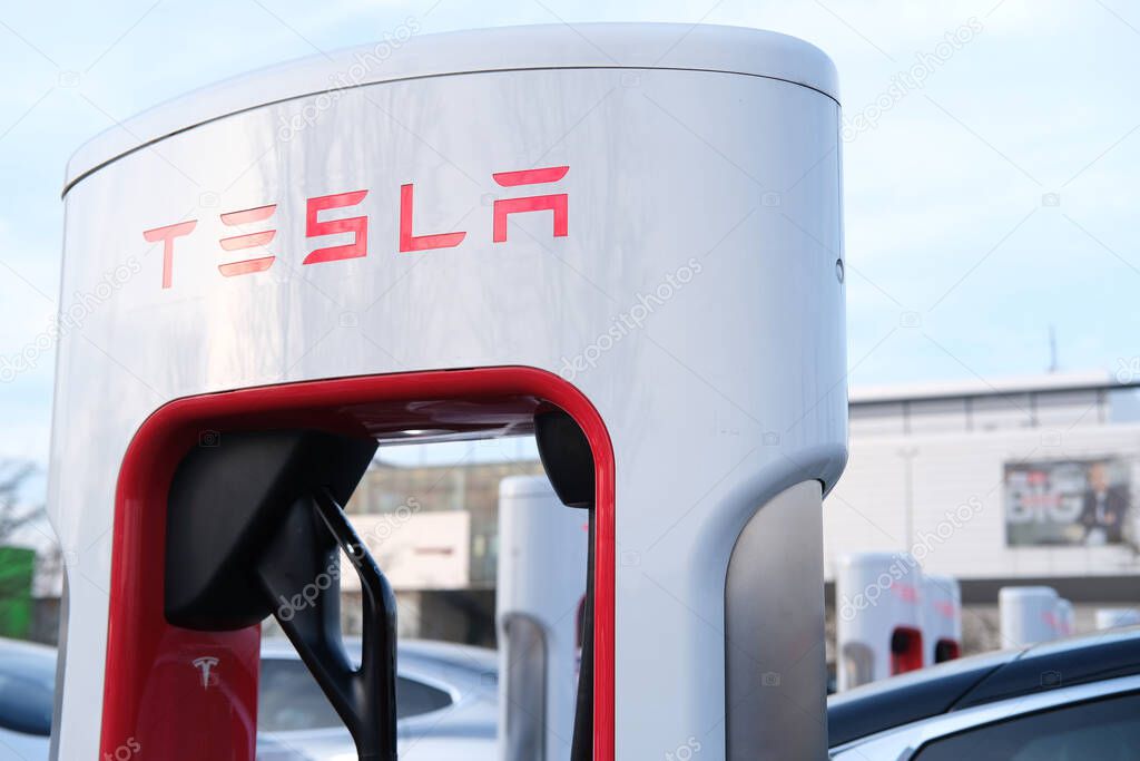 close-up of Tesla passenger electric cars, modern vehicles replenishes battery at charging station, alternative energy development concept, electric vehicle production