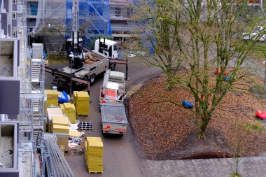 Frankfurt, Almanya - Ocak 2022: Evi tamir eden işçiler, vinçle yalıtım malzemelerini kaldıran işçiler, üretim işi konsepti, konut stoklarının yenilenmesi, özel ekipmanlar