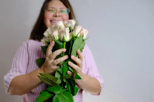 白の花束のクローズアップ ピンクのバラ 大人の女性の手の中に ガールフレンドとの日付に花をもたらした ボーイフレンド お母さんに与える 母の概念 バレンタインデー 誕生日 クリスマスプレゼント — ストック写真