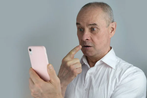 Close Homem Carismático Maduro Olha Para Tela Telefone Capa Rosa — Fotografia de Stock