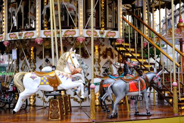 Çocuklar için atlıkarınca, çok renkli ampullerle, dekorasyonlarla süslenmiş, neşeyle dönen, çocuklar için atlarla parkta panayır eğlencesi, tatil konsepti, Noel, aile eğlencesi