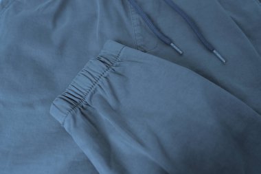 Mavi pamuk pantolon deseninin yakın çekimi, çizgili cepli pantolon, bilek kelepçesi, belinde ip, çek kalitesi konsepti, modaya uygun giysi.