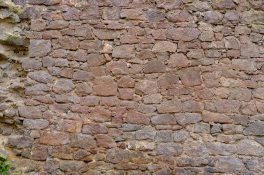 beautiful vintage texture of the wall of a medieval castle built in middle of 14th century, multi-colored volumetric stones for designer, wallpaper, rough sandy texture. Background for designer