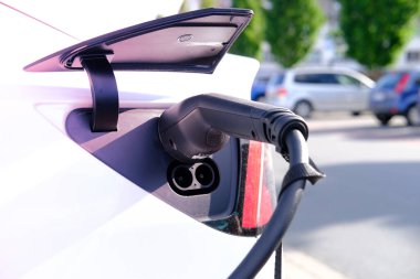 Beyaz arabanın enerji şarj eden kısmının kapatılması, şarj istasyonunun yenilenmesi, alternatif enerji geliştirme konsepti, elektrikli araç üretimi, küresel işletme, elektrik enerji depolama