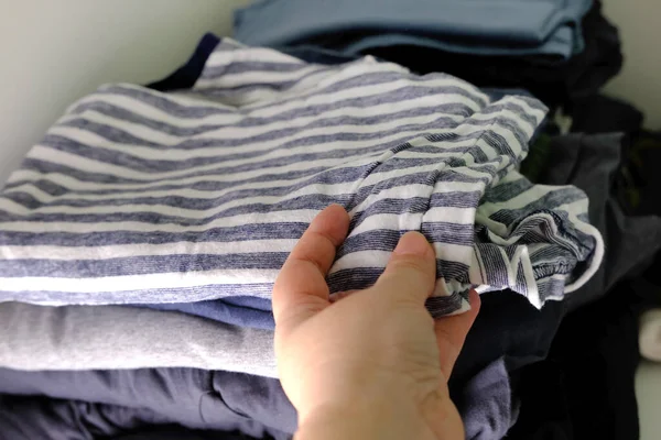 Крупный План Женской Руки Держит Сложенную Одежду Шкафу Полке Вещи — стоковое фото