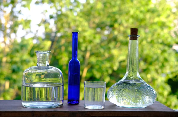 Massor Olika Glasflaskor Karaff Och Flaskor Bordet Träbord Trädgården Vacker — Stockfoto