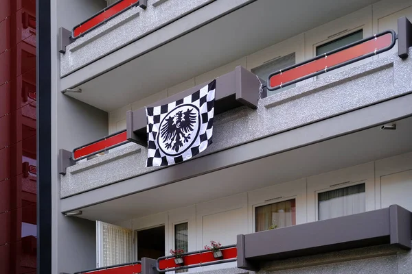 silk Eintracht Frankfurt flag on facade building, on balcony in Frankfurt, concept of logo, creative art, black and white checkered flag, German football club, community of fans and supporters