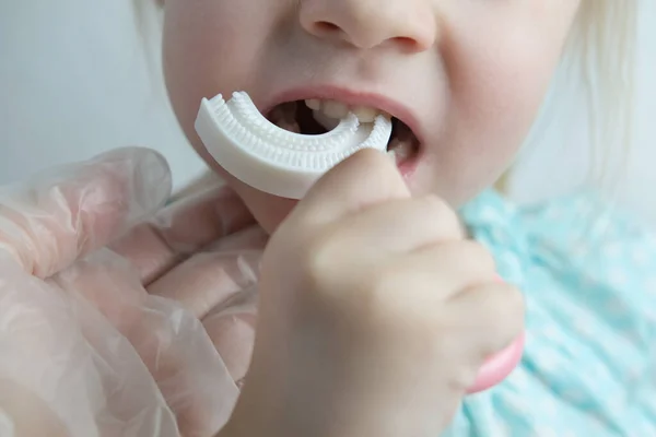 医生教儿童 小病人用硅胶刷牙 特写儿童牙 儿科概念牙 牙科治疗 矫正牙合 口腔保健 防止龋病 — 图库照片