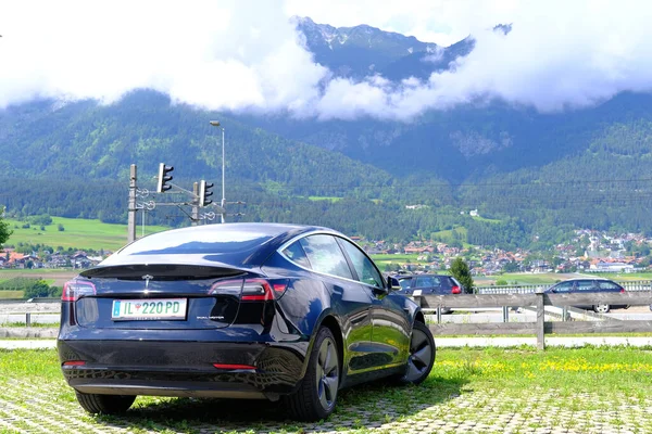 ブラックテスラライト電気自動車は オフィスの前に駐車場に立って 代替エネルギー開発コンセプト 電気自動車生産 電気エネルギー貯蔵 インスブルック オーストリア 6月2022 — ストック写真