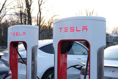 Tesla yolcularının yakın çekimleri elektrikli arabalar, modern araçlar şarj istasyonunda aküyü dolduruyor, alternatif enerji geliştirme konsepti, elektrikli araç üretimi
