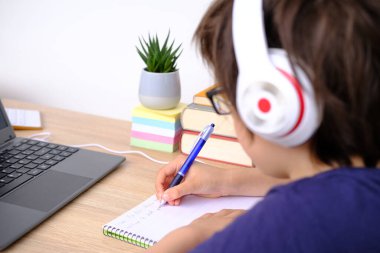 çocuk, çocuk 9-10 yaş, gözlüklü ve kulaklıklı ilkokul öğrencisi elektronik hesap makinesinde matematiksel örnekler hesaplıyor, okul konseptine geri dönüyor, genç işadamı, sınıf dâhisi çocuk