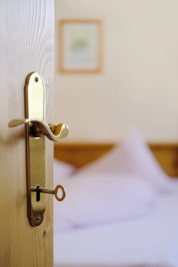 Otel odasındaki anahtar deliğinde, yatakta, kalp şeklinde battaniye, iki yastık, beyaz pamuklu çarşaf, sağlıklı uyku konsepti, uykusuzluk problemleri, otel odasında rahat bir konaklama