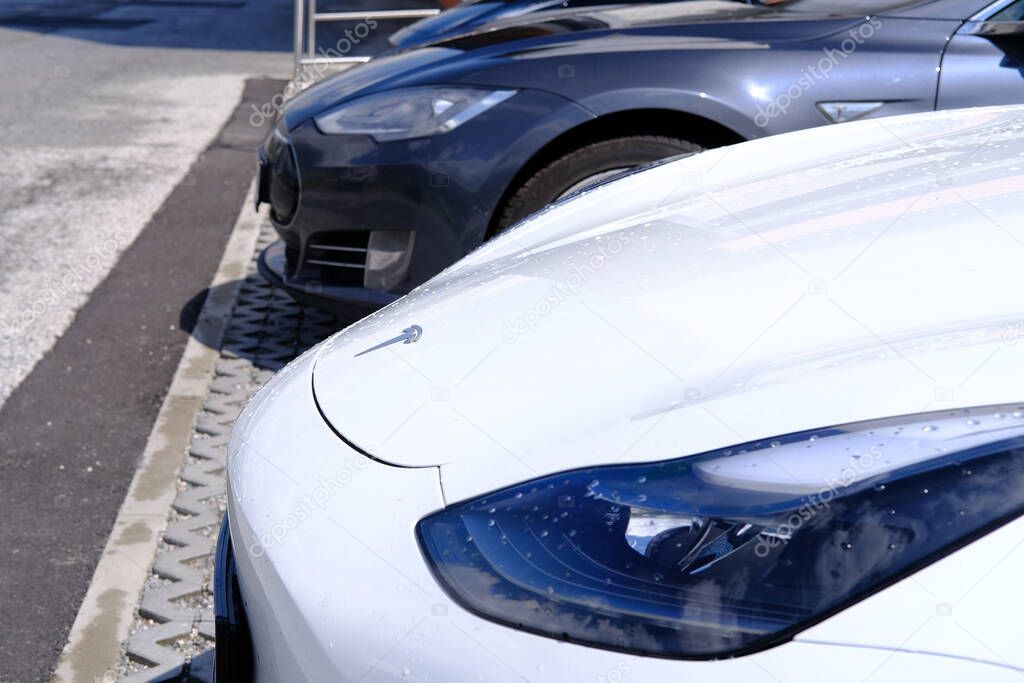 white Tesla light electric car stands in parking lot in front of office, alternative energy development concept, electric vehicle production, electric energy storage, Innsbruck, Austria - June 2022