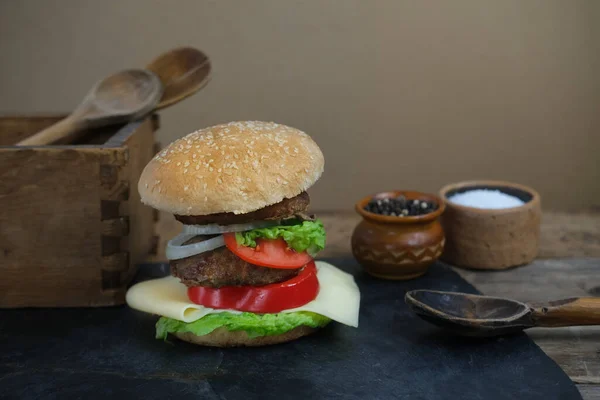 appetizing big Cheeseburger, hamburger with ingredients, delicious beef meat patties, cheese, lettuce, tomato slices, ruddy bun with sesame seeds, retro style, food levitation conceptspace for text